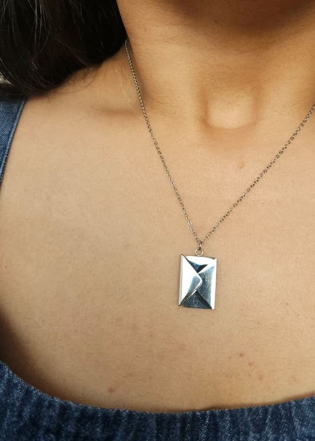 Necklace with a geometric pendant worn by a person