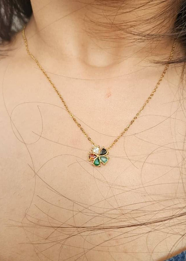 Gold necklace with a colorful pendant on a person's neck