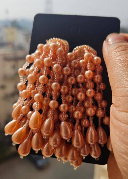 Pearl necklace on a card held by a hand with a blurred background